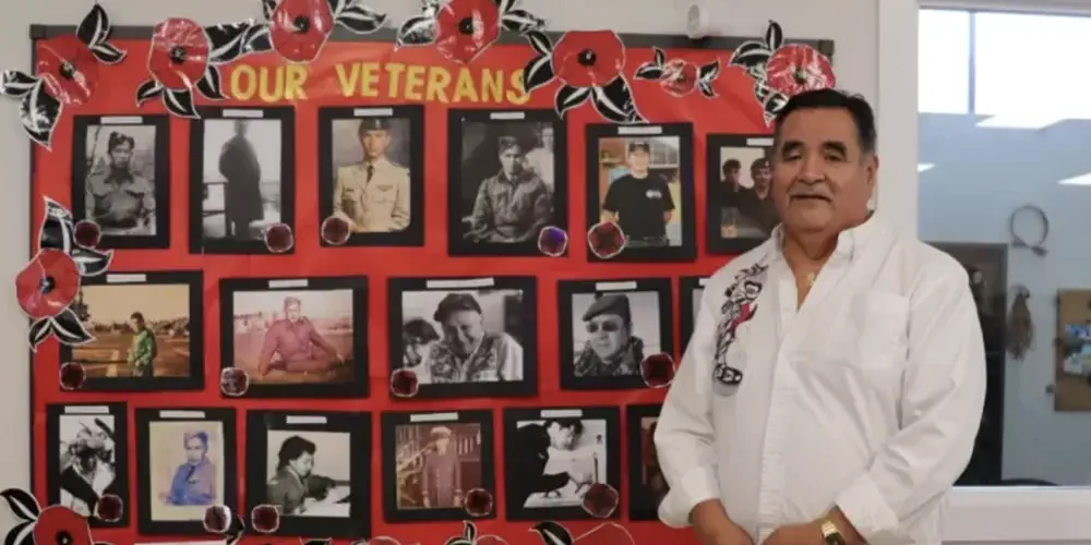 Dave Jacobson, Usma Elder's Coordinator with a poster of photos of Nuu-chah-nulth war vets.