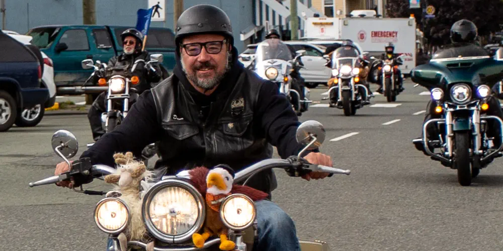Dave Wiwchar, chair of the Port Alberni Toy Run, smiles from his motorbike in front of other riders.