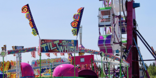 Pink carnival rides against a clear blue sky.
