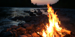 A campfire burns at sunset.