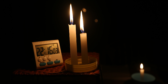 Candles illuminate a small digital clock that reads 10:16pm.