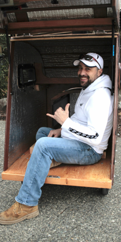 A man smiles while sitting inside the tiny home pod.