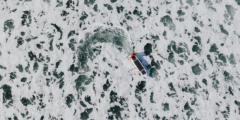 A driverless boat zips on top of a frothy ocean.