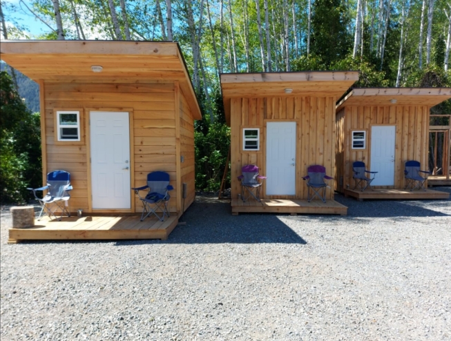 A shot of the Scarlet Ibis adventure huts on a sunny day. They're small but cozy.