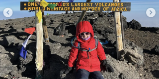 Autumn Lott grins at the top of Mount Kilimanjaro.