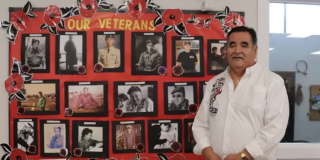 Dave Jacobson, Usma Elder's Coordinator with a poster of photos of Nuu-chah-nulth war vets.