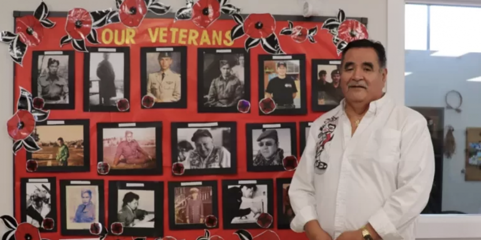 Dave Jacobson, Usma Elder's Coordinator with a poster of photos of Nuu-chah-nulth war vets.