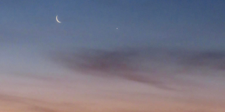 A crescent moon at sunrise.