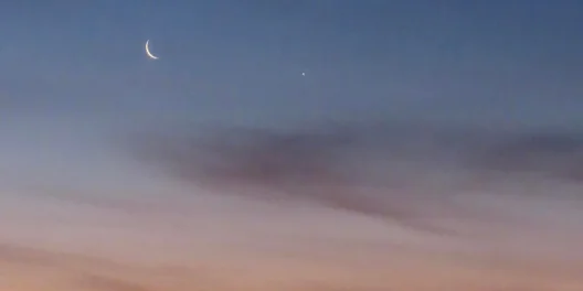 A crescent moon at sunrise.