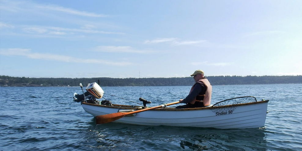 Laird sits in his boat, Strikes 90, on a sunny day.