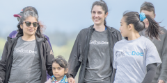 A group of pepole walk and smile wearing Walk with your Doc t-shirts.