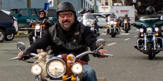 Dave Wiwchar, chair of the Port Alberni Toy Run, smiles from his motorbike in front of other riders.