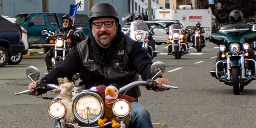 Dave Wiwchar, chair of the Port Alberni Toy Run, smiles from his motorbike in front of other riders.