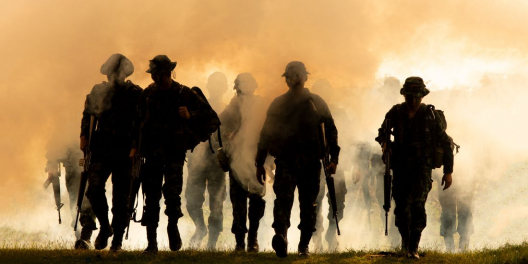 A silhouette of soldiers walking from behind.