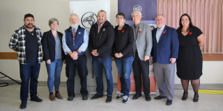 Representatives from the Huu-ay-aht First Nation, provincial and federal governments stand together for a photo.