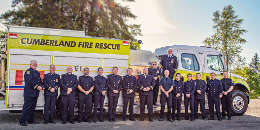 The Cumberland Volunteer Fire Department poses in front of one of their fire trucks.